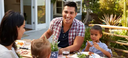 family enjoying meal in backyard